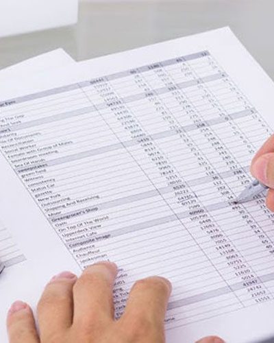 Accountant reviewing a ledger with a calculator